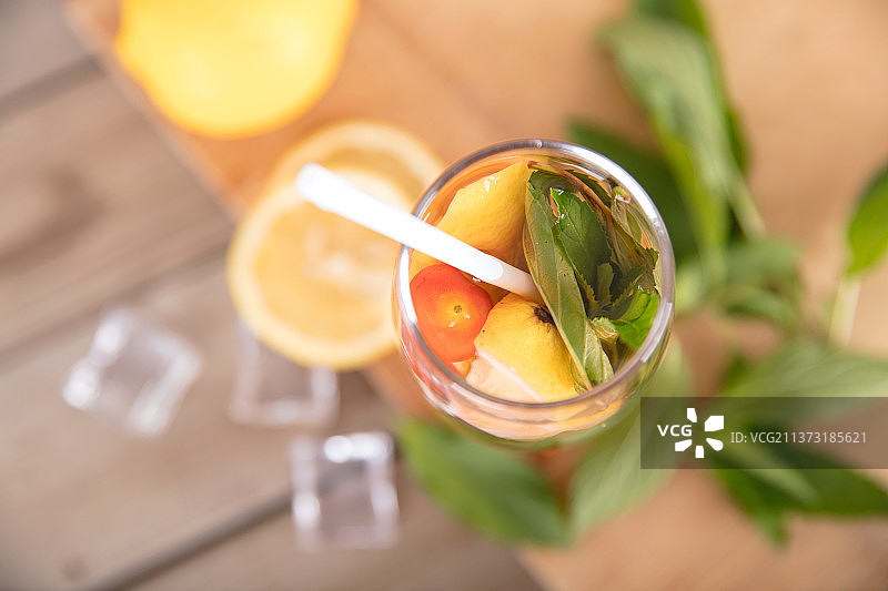 砧板上的冰镇柠檬薄荷水和杯子旁的新鲜柠檬果及冰块和鲜薄荷叶图片素材