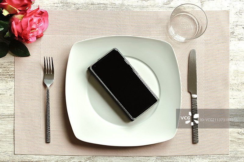 俯拍桌上的智能手机和餐具图片素材