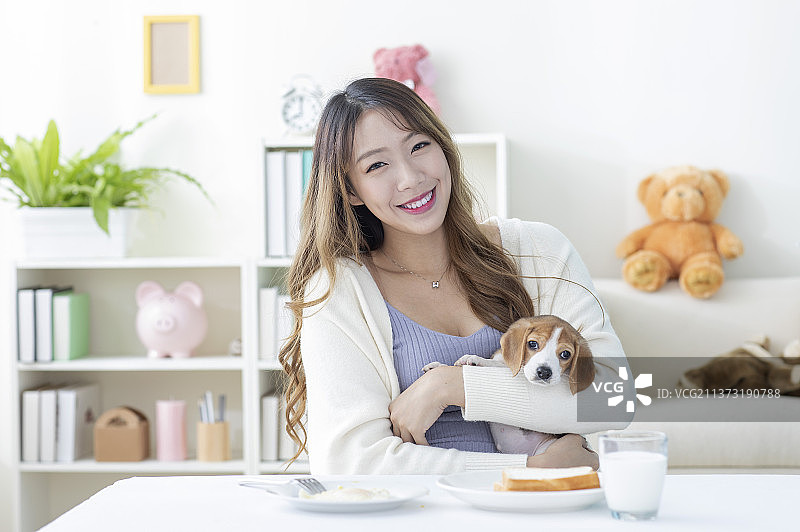 东方美女抱着米格鲁准备享用早餐图片素材