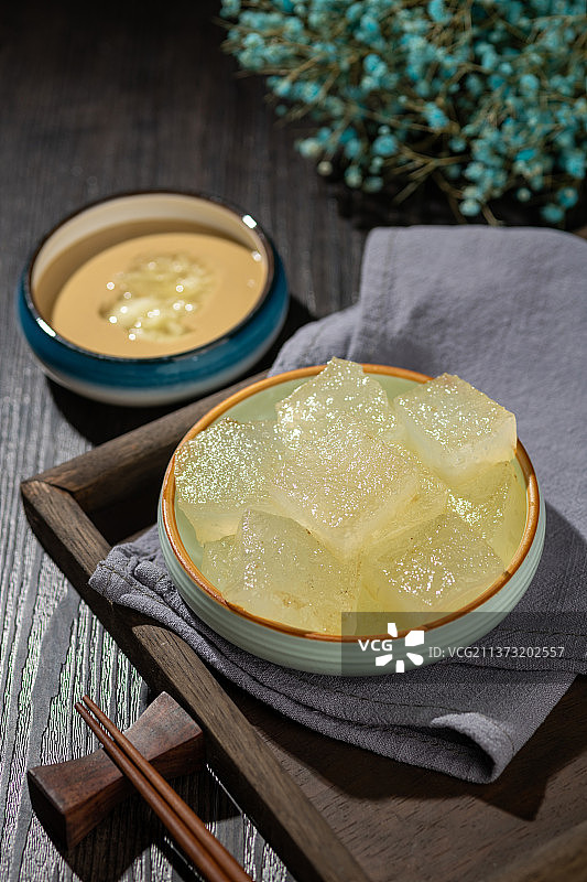 天津小吃焖子特写木桌面深色调图片素材