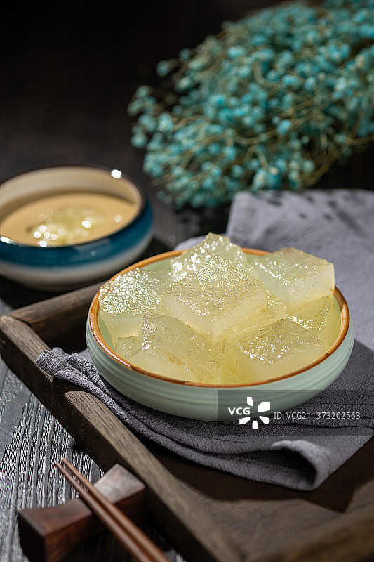 天津小吃焖子特写木桌面深色调图片素材