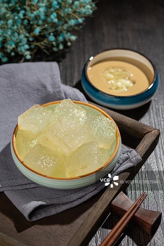 天津小吃焖子特写木桌面深色调图片素材