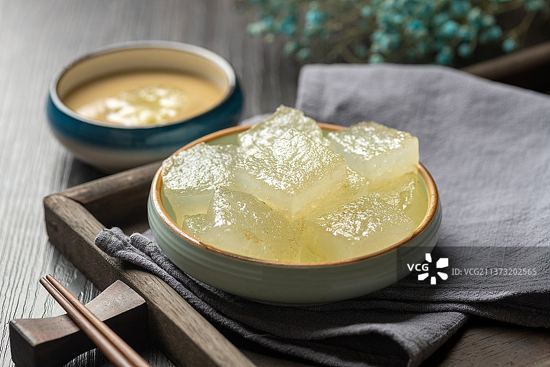 天津小吃焖子特写木桌面深色调图片素材