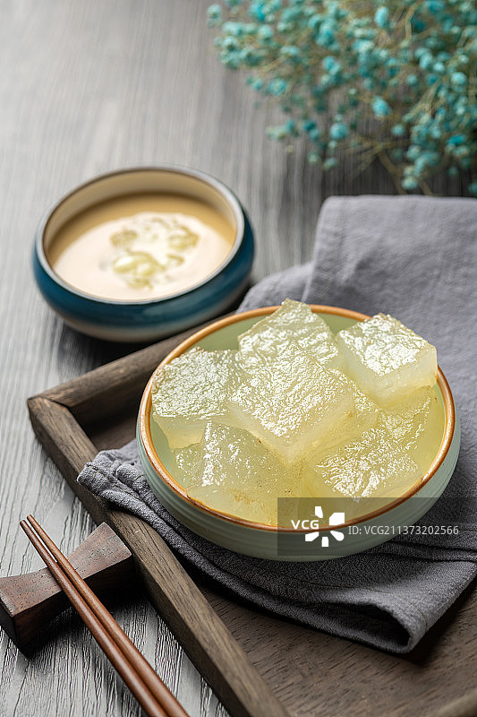 天津小吃焖子特写木桌面深色调图片素材