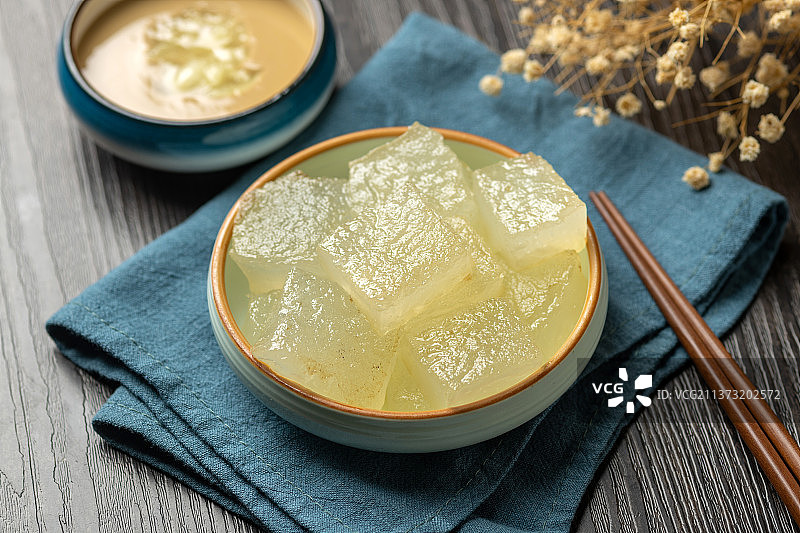 天津小吃焖子特写木桌面深色调图片素材