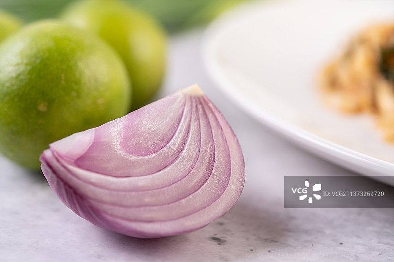 水泥地上切半的洋葱和青柠图片素材