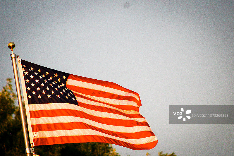 彩色旗帜，低角度视角下的美国国旗，背景是晴朗的天空图片素材