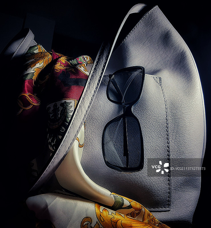 黑色背景上的白色皮革钱包和太阳镜特写图片素材