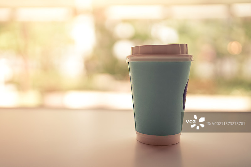 在咖啡馆喝热咖啡，桌上的一次性杯子特写图片素材
