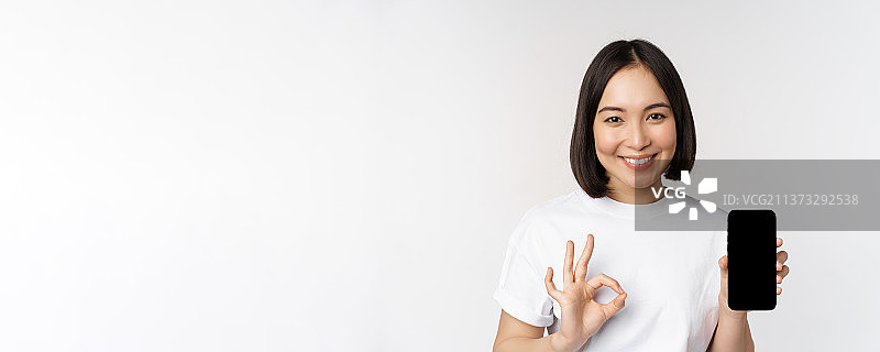 微笑的亚洲女性展示OK手势，推荐手机屏幕图片素材