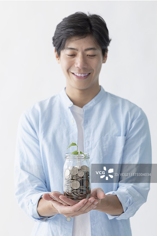 中年男性双手捧着储蓄罐图片素材