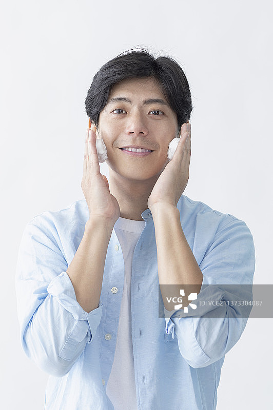 中年男性双手放在脸颊两边微笑地清洁脸部图片素材