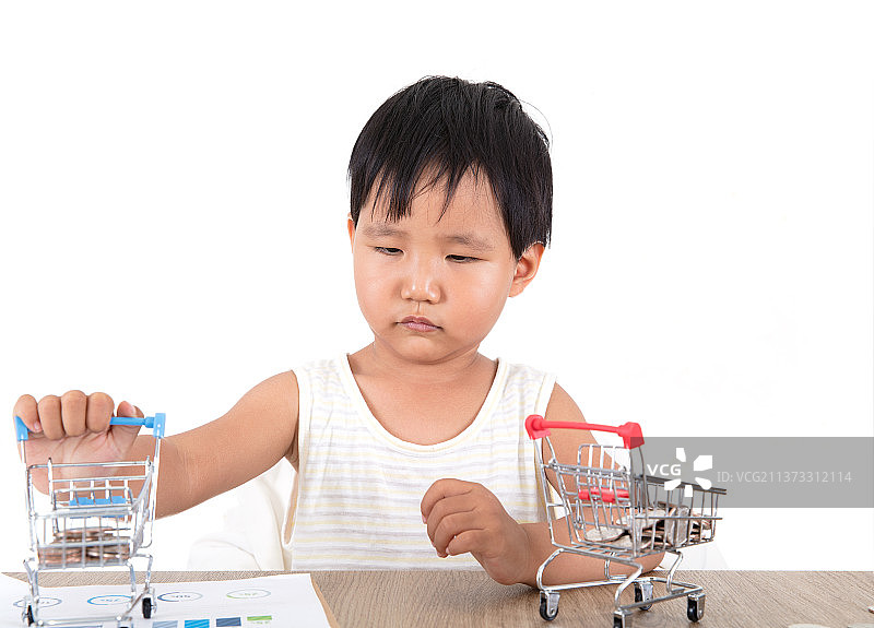 可爱的中国小女孩在玩耍桌子上盛着美元硬币的小购物车同时还有金融资料图片素材
