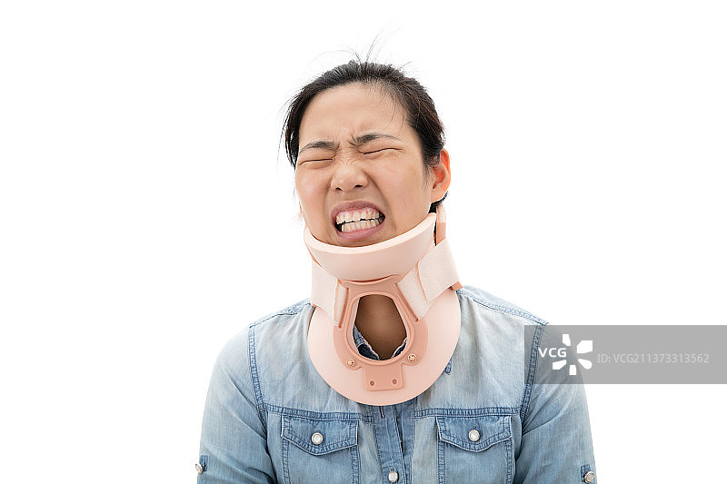 白背景前由于劲椎病带着劲托表情痛苦的年轻女孩图片素材