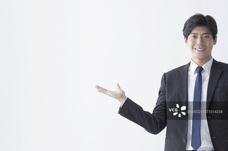商业男性微笑地站著作展示的手势图片素材