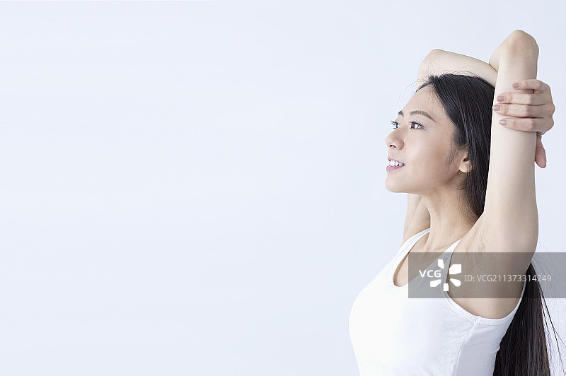 东方美女手臂交叉放在头上作伸展动作图片素材
