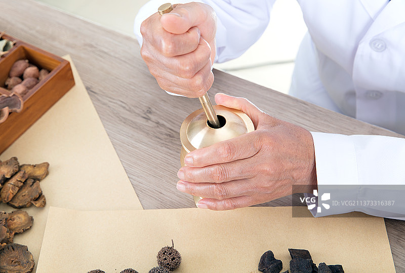 特写拍摄老中医正在使用药臼捣碎中草药图片素材