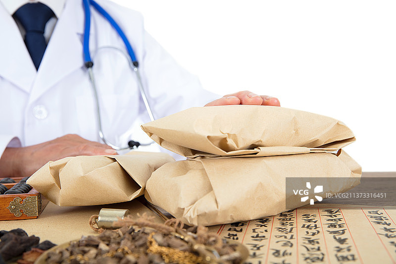 中医大夫正把包好的药材给予患者图片素材