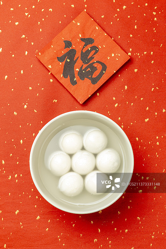 元宵节美食元宵汤圆特写红色洒金背景图片素材