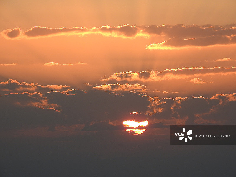 红色天空下山脉中的黄色夕阳特写图片素材
