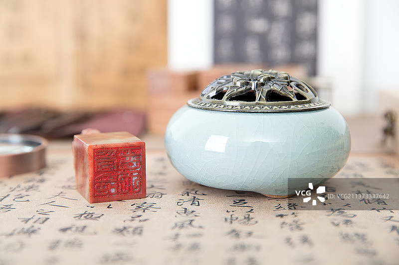 书房桌子上的书法作品以及作品上的印章和香炉图片素材