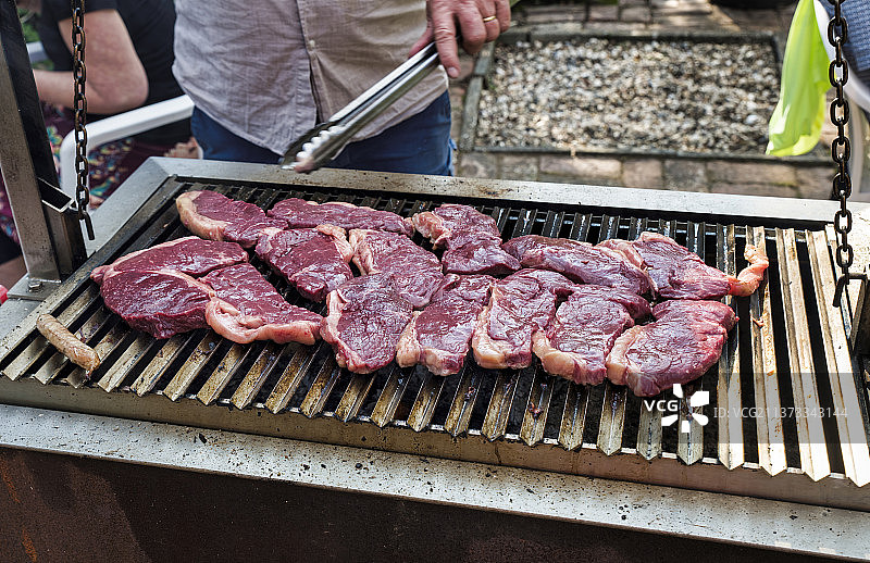 男人在烧烤架上烤牛排图片素材