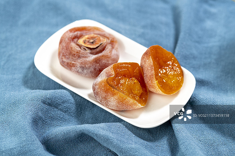 一盘流心柿饼子特写暖色莫兰迪色系背景图片素材