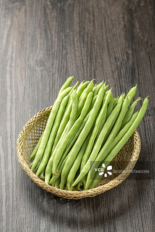 一簸箕豆角四季豆摆放在木桌面上图片素材