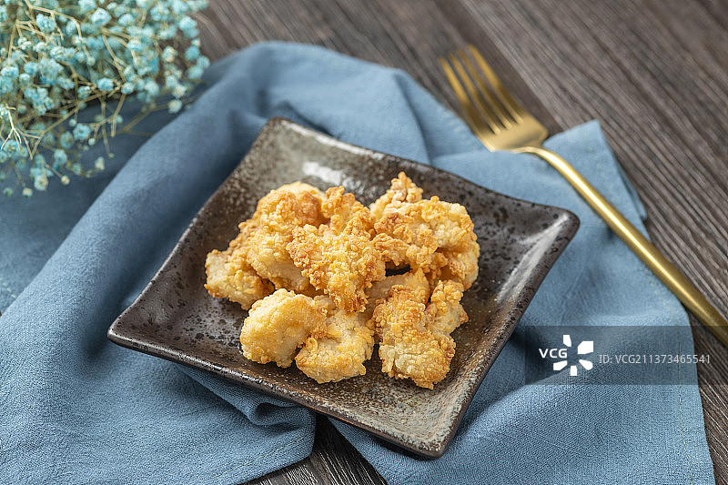 一盘鸡米花橙汁金色叉子特写图片素材