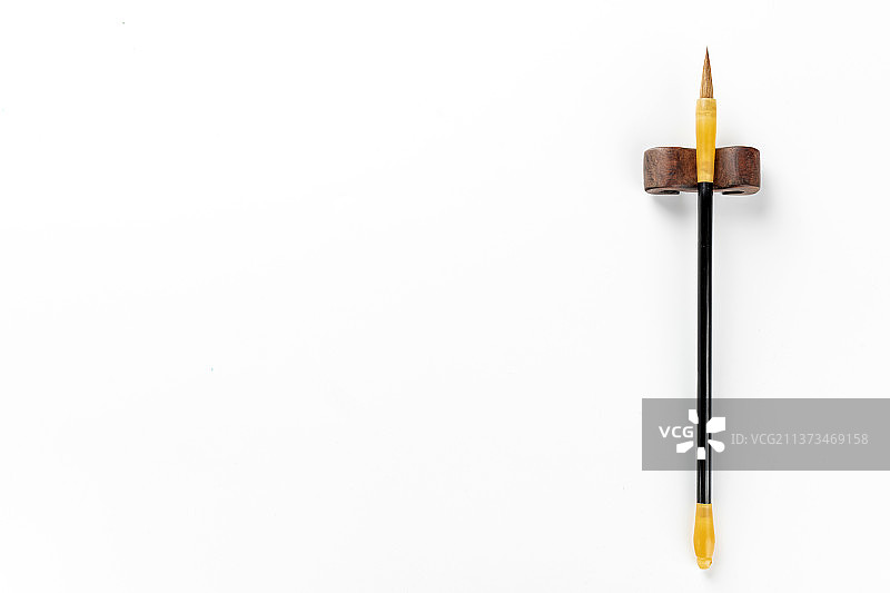 一支架在笔架上的毛笔特写白色背景图片素材