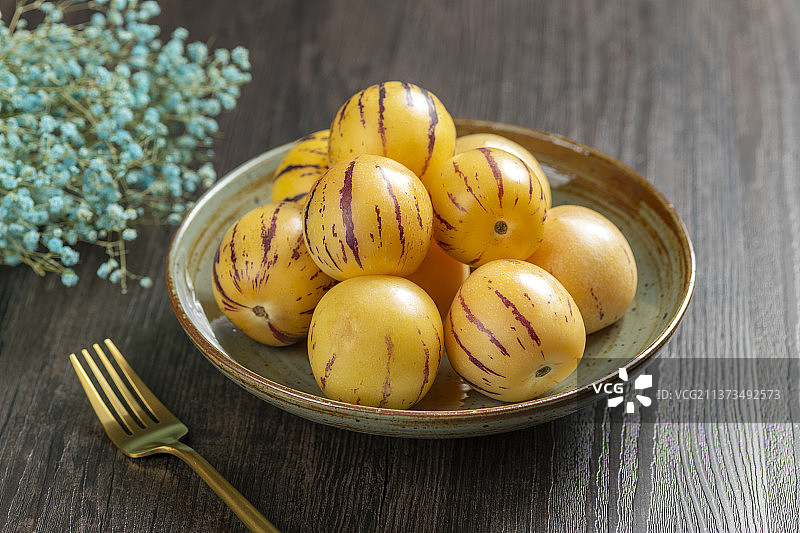 一盘人参果摆放在桌面上特写图片素材