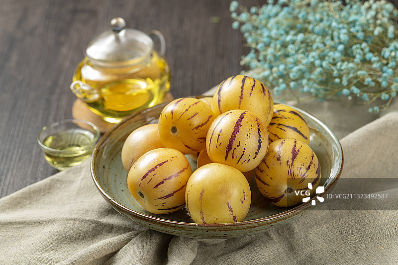 一盘人参果摆放在桌面上特写图片素材