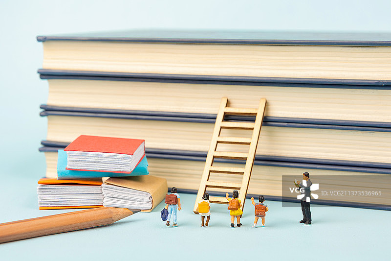 微缩景观老师在书本前教导学生学习升学图片素材