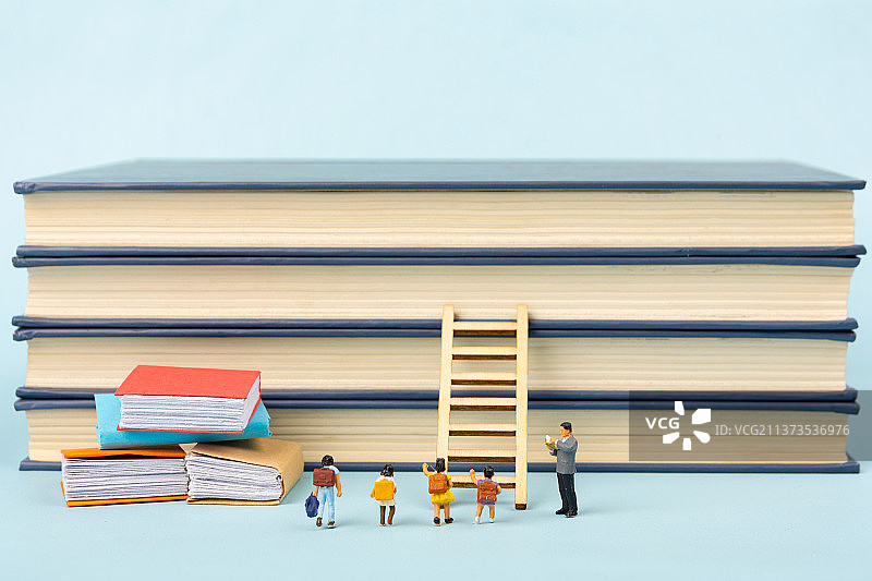 微缩景观老师在书本前教导学生学习升学图片素材