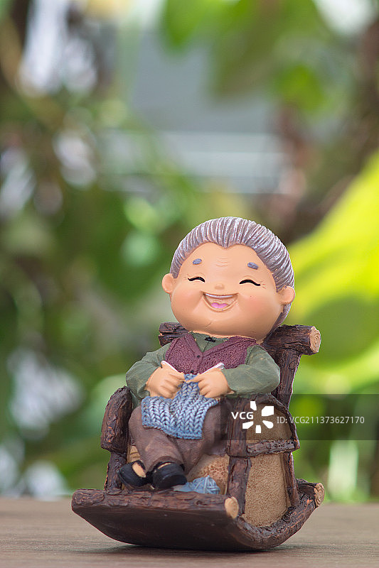 坐着摇椅织着毛衣满面笑容的老奶奶雕塑模型图片素材