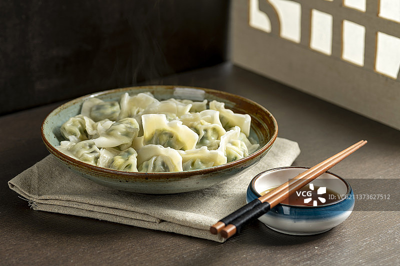一盘水饺摆放在古窗棂木桌面上图片素材