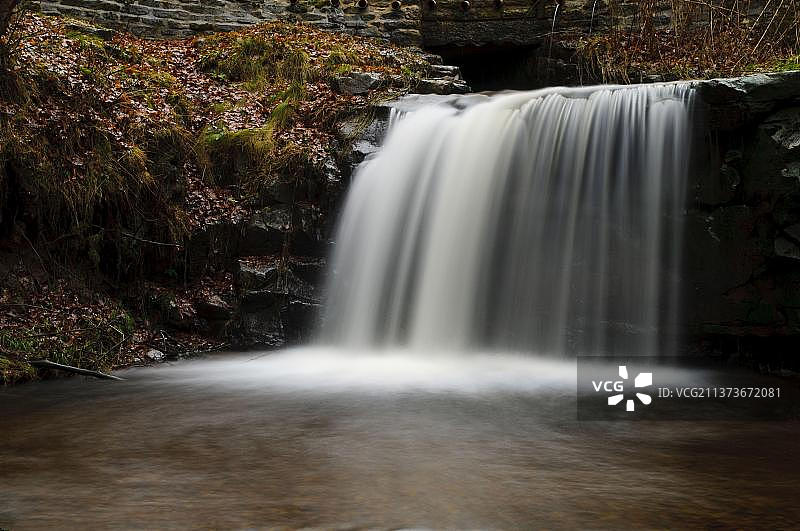 北约克郡荒原国家公园霍恩比附近的布洛吉尔的森林中的瀑布和河流，遍地落叶图片素材