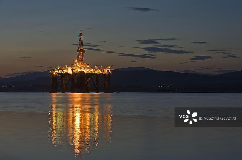 夜间停泊在靠近海岸的海上的石油钻井平台，克罗马蒂湾，默里湾，因弗戈登，复活节罗斯，苏格兰，英国，欧洲图片素材
