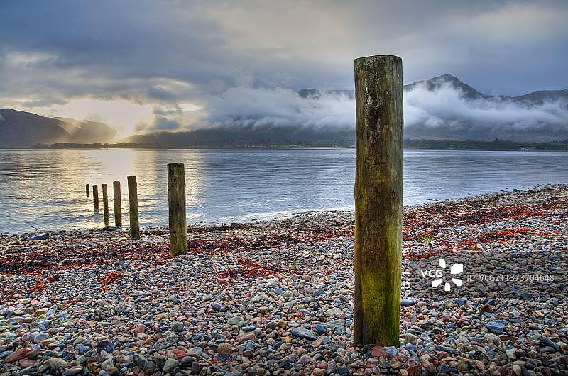 日落时分Loch Linnhe湖岸边的木杆，奥尼奇，高地，苏格兰，英国，欧洲图片素材