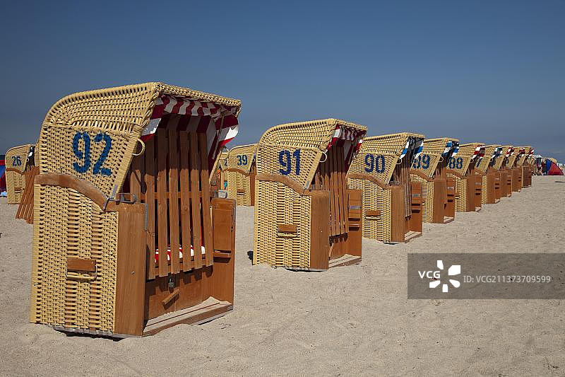 海滩上一排带顶棚的柳条沙滩椅，德国梅克伦堡-前波美拉尼亚州波尔岛蒂门多夫的波罗的海度假小镇，欧洲图片素材