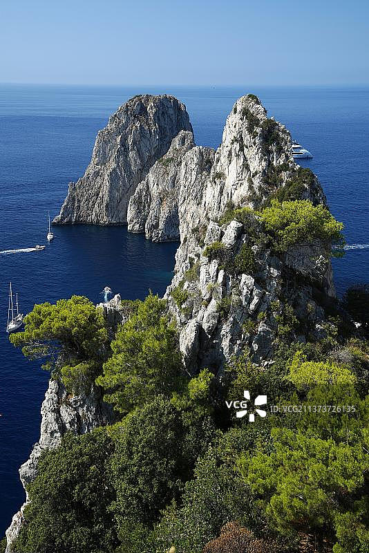 意大利坎帕尼亚卡普里岛法拉格利奥尼岩石海岸与海上的船只图片素材
