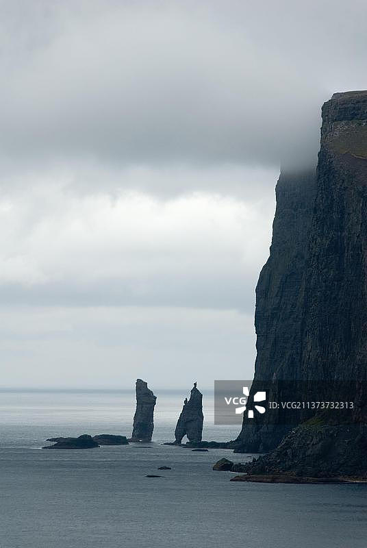 岩石海岸，悬崖，巨人和他的巨魔妻子，科勒角，欧洲丹麦法罗群岛东岛图片素材