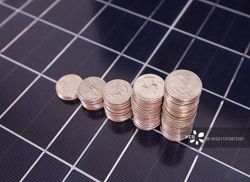 太阳能背景上一排递增的美元硬币图片素材