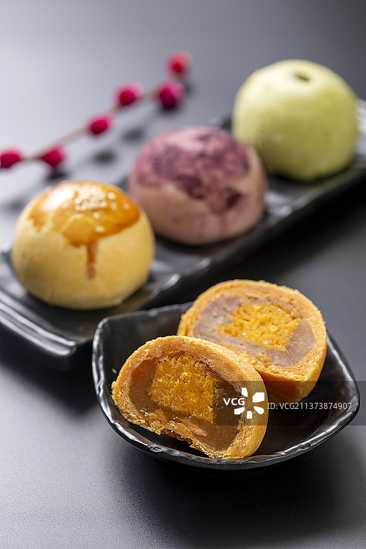 一盘蛋黄酥茶水特写黑色背景图片素材