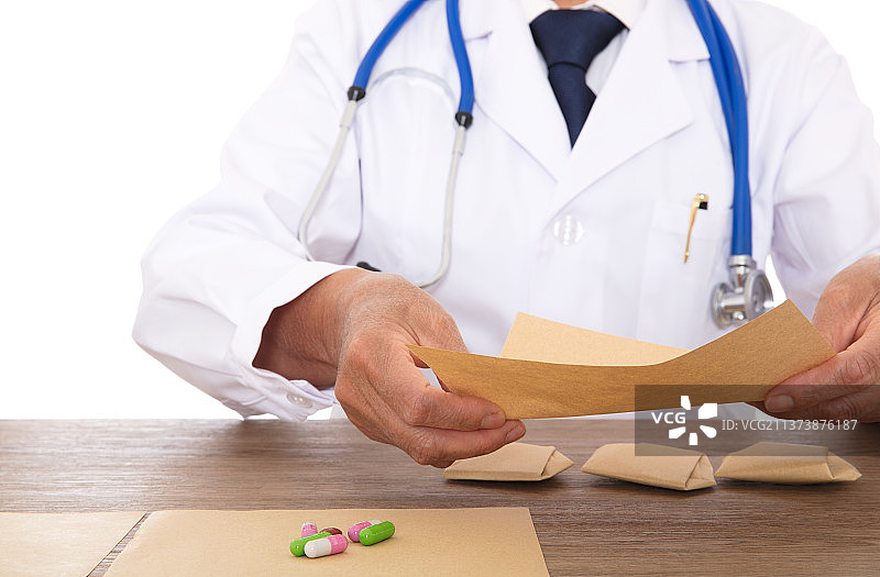 西医大夫在把配好的药品用纸张包起来图片素材