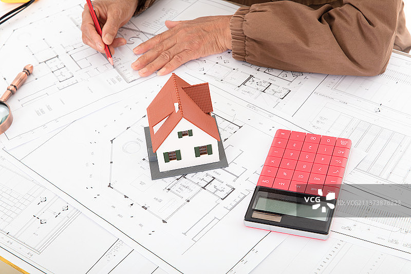 特写拍摄设计师使用铅笔在图纸上修改建筑设计图图片素材