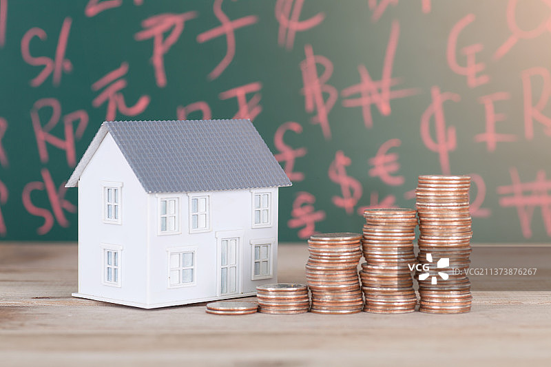 房子模型和一排递增的美元硬币图片素材