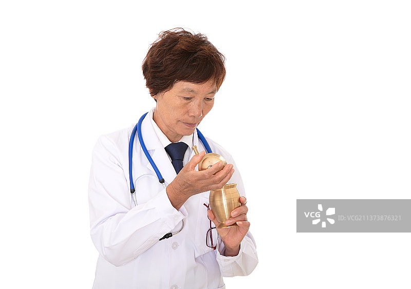白背景前的中医大夫查看药臼里药材的情况图片素材