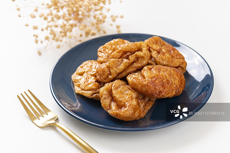 一盘油面筋特写白色背景图片素材
