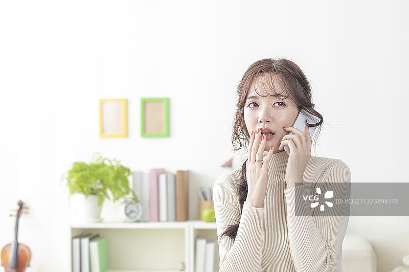 一边讲电话露出惊讶的表情图片素材